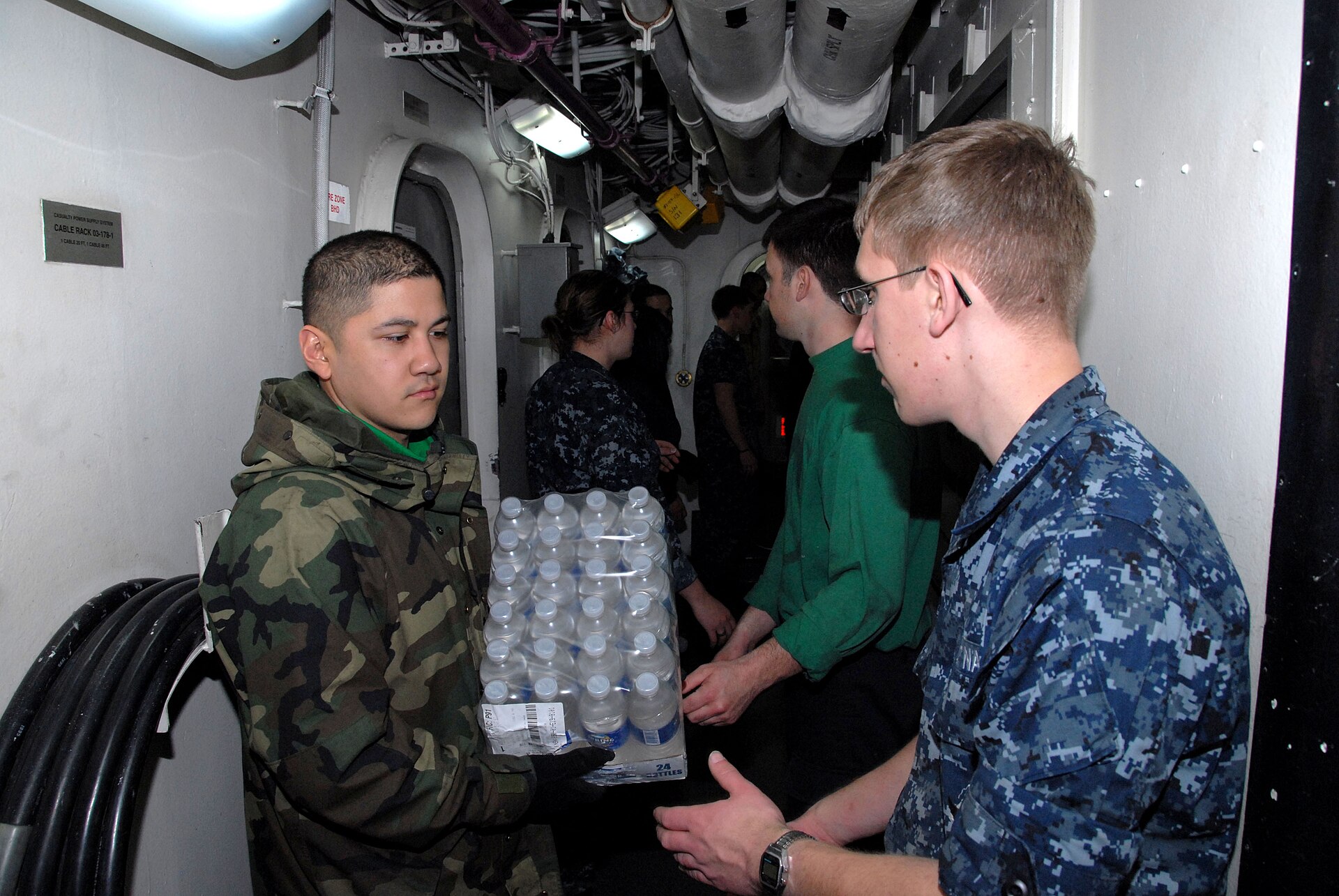 US Navy 110314-N-KF029-060 Sailors aboard the aircraft carrier USS Ronald Reagan (CVN 76) move cases of drinking water aboard the aircraft carrier